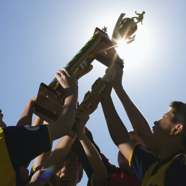 a-group-of-boys-in-soccer-team-shirts-holding-a-trophy-and-celebrating-a-win-.jpg